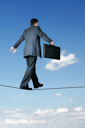 Managing during a turnaround is like this businessman successfully walking a tightrope.  We can help you achieve the careful balance needed to pull back into the black.