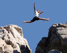 Like this climber jumping the chasm between a pinnacle and cliff we help you bridge the gap between developing and commercializing your product or service.