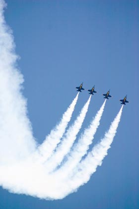 Four jets trailing white smoke reversing a dive in synchronization to climb back up into a bright blue sky.  Everyone needs to get in step and move together to turn a company around.